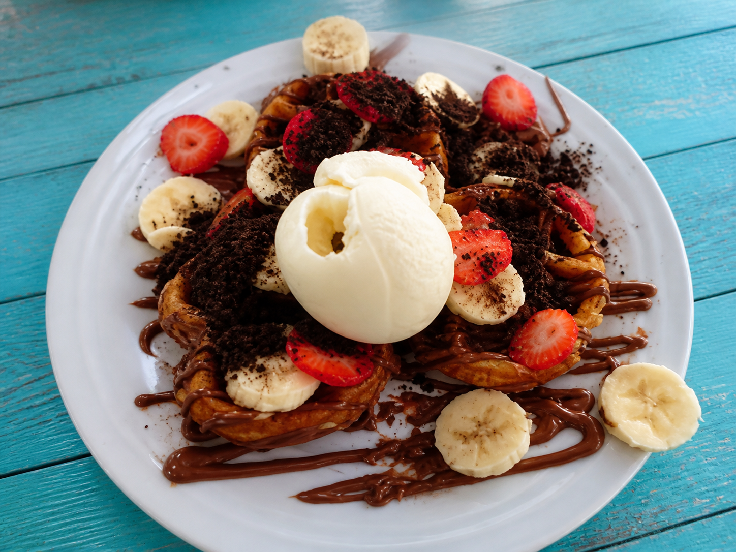 Breakfast plate with waffle, fruit, chocolate and ice cream